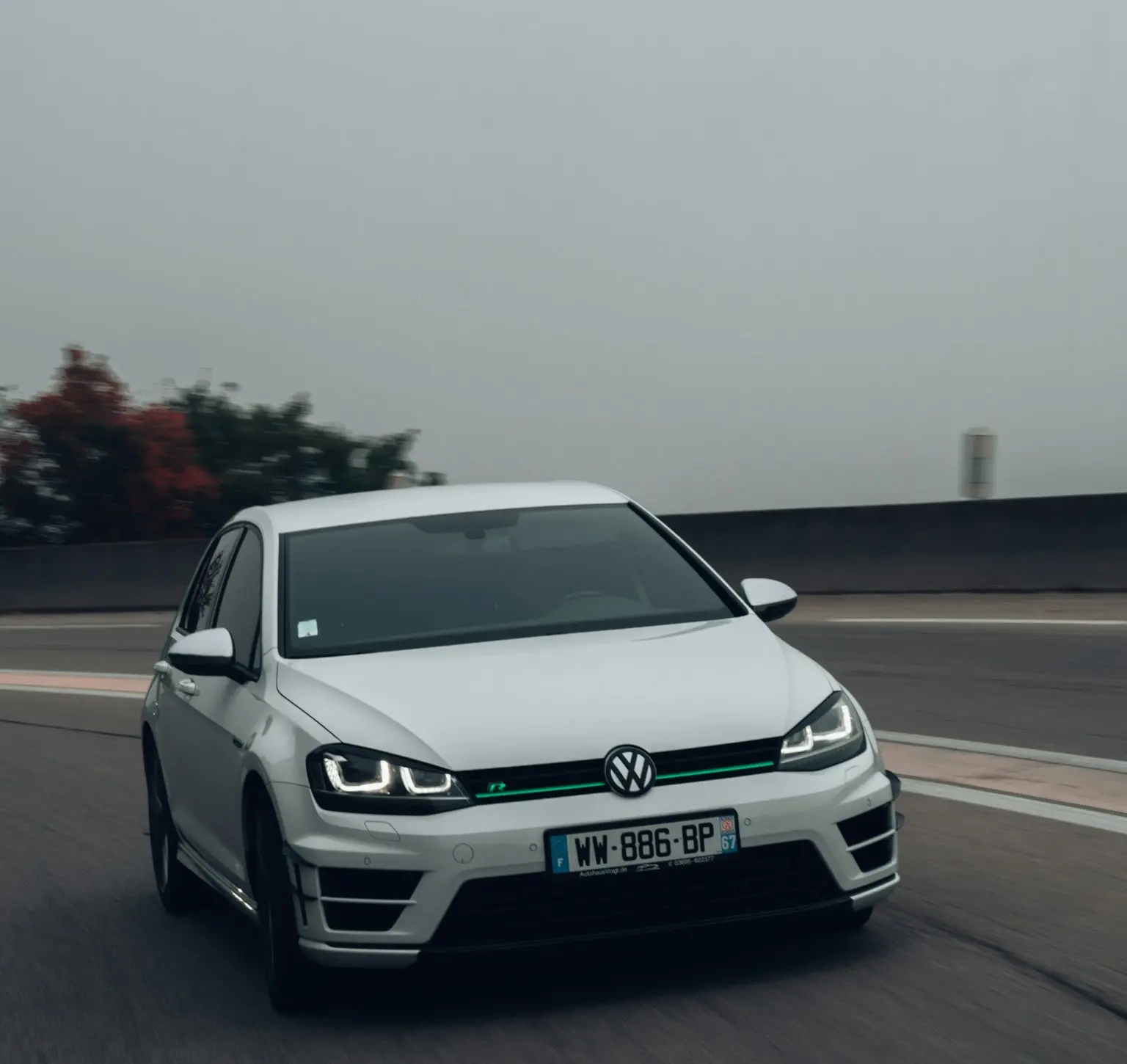 a white volkswagen car driving down a road
